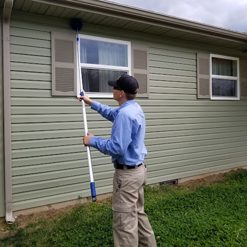 Plank Termite & Pest Control technician providing exterior service at a home